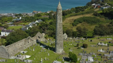 vista aérea,4k, vuelo, torre redonda ardmore construida en el siglo xii y las ruinas de una catedral que data de los siglos xii y xiii