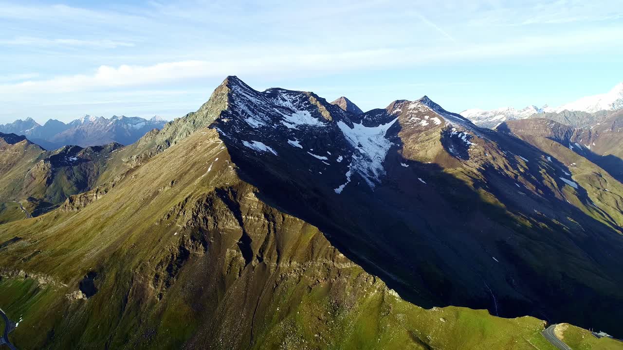Golden light spills of dramatic alpine ridges, snowy peaks in the Austrian Alps
