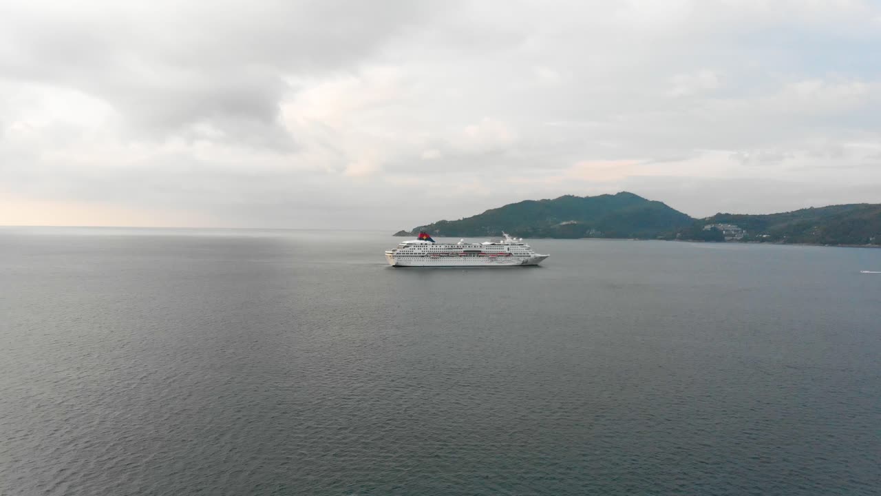 프레임의 오른쪽에서 오는 스피드 보트와 태국 남쪽의 푸켓의 트리 트랑 섬의 배경에 접근하고 있습니다.