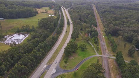 Fahrzeuge,-Die-Auf-Dem-Pacific-Highway-Mit-üppigen-Grünen-Bäumen-Im-Wald-In-Der-Nähe-Des-Middle-Brother-National-Park,-NSW,-Australien-Fahren