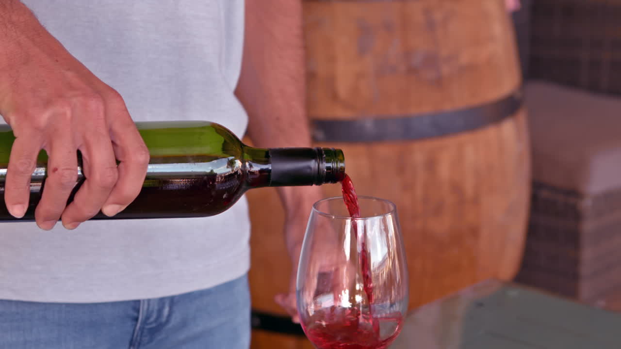 sommelier vertiendo vino rojo en una copa de vino en cámara lenta