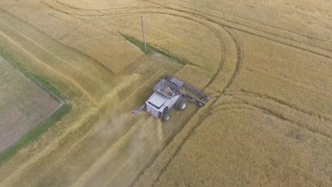 Vista-Aérea-Dando-Vueltas-Sobre-Cosechadora-En-Campo-Rural-En-Cámara-Lenta