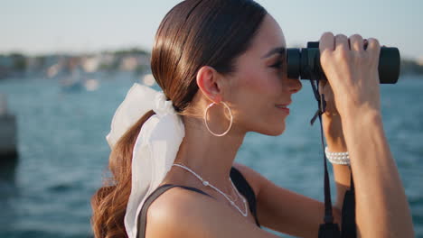 mujer con binoculares junto al agua