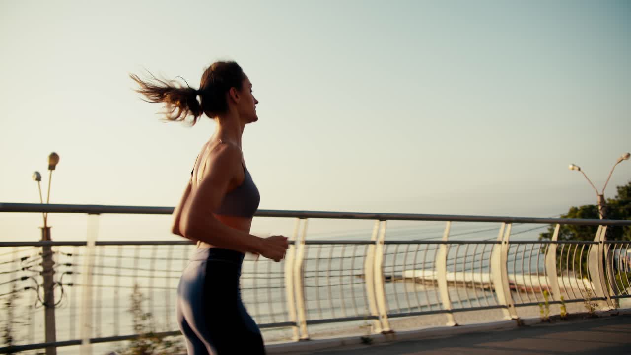 Top view of a happy athletic girl in a sports summer uniform who is jogging in the morning