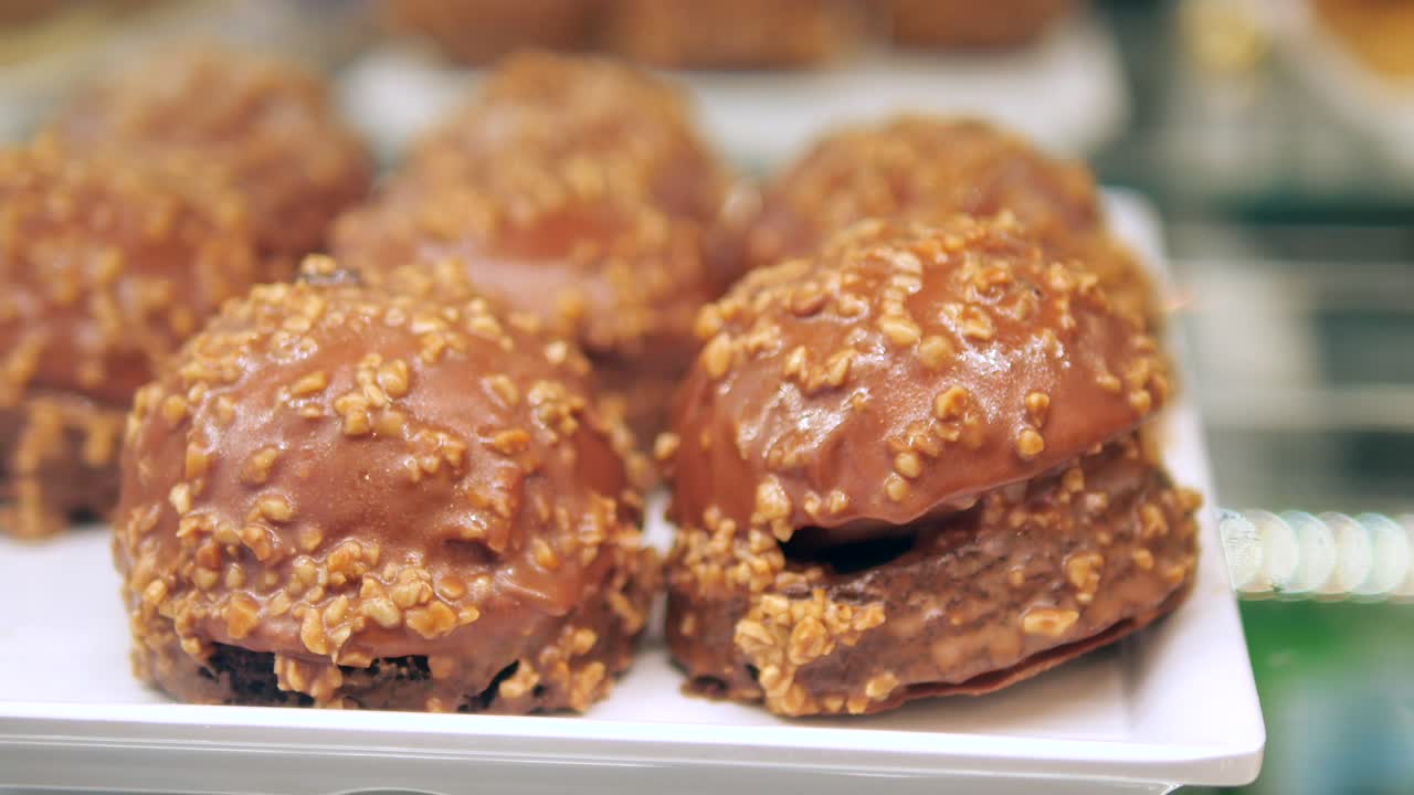 Deliziosi dolci al cioccolato guarniti con noci tritate su un vassoio