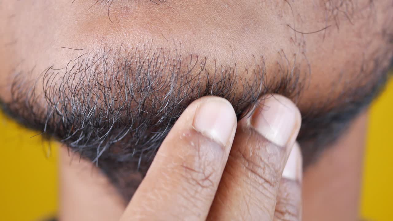 젊은이가 거울에 자신의 얼굴 피부를 확인하고,