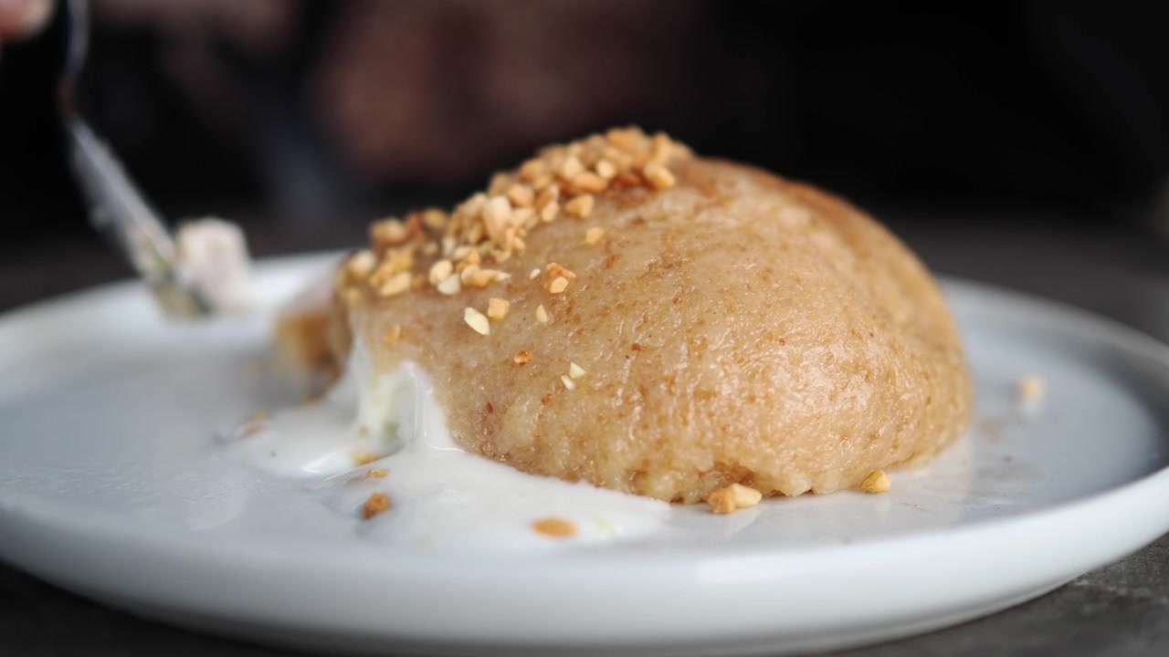 Person Eating Semolina Halva with Ice Cream and Crushed Nuts
