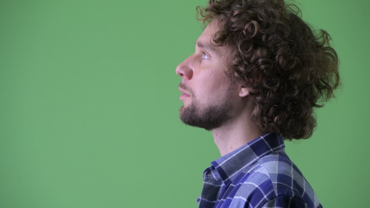 Young handsome bearded hipster man with curly hair