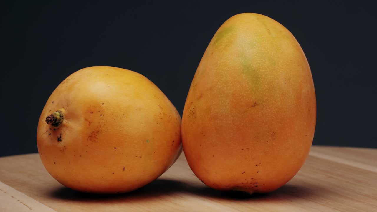 Two Ripe Mangoes on Wooden Table