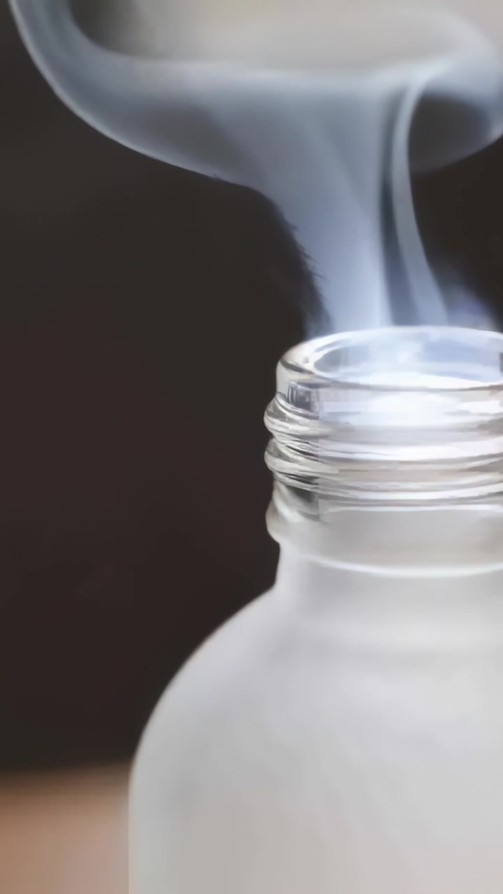 Vidéo verticale : Vapeur s'élevant d'un col givré, s'enroulant tandis qu'une barre blanche se déplace au-dessus d'un fond sombre, avec espace pour le texte.