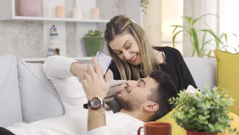 Marido-Y-Mujer-Felices-Disfrutando-De-Pasar-Tiempo-Juntos-Mientras-Se-Sientan-En-El-Sofá-Y-Se-Relajan.