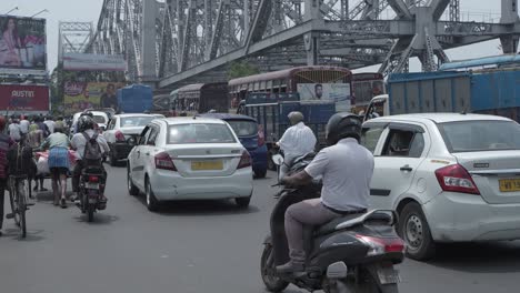 busy kolkata street traffic with howrah bridge and yellow taxis