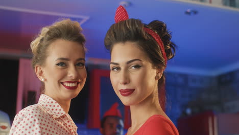 two rockabilly women blowing kisses in a retro restaurant