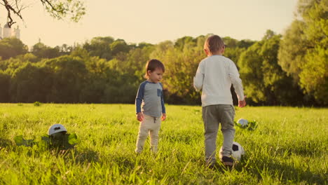 dos niños lindos jugando al fútbol juntos en verano. niños jugando al futbol al aire libre