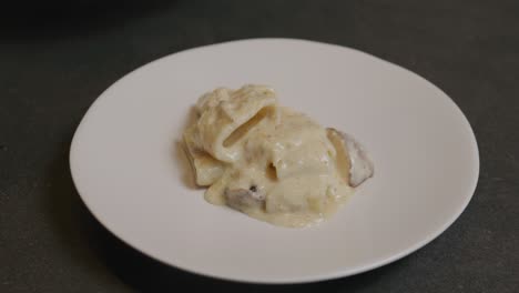 a chef meticulously plates a dish of creamy truffle pasta