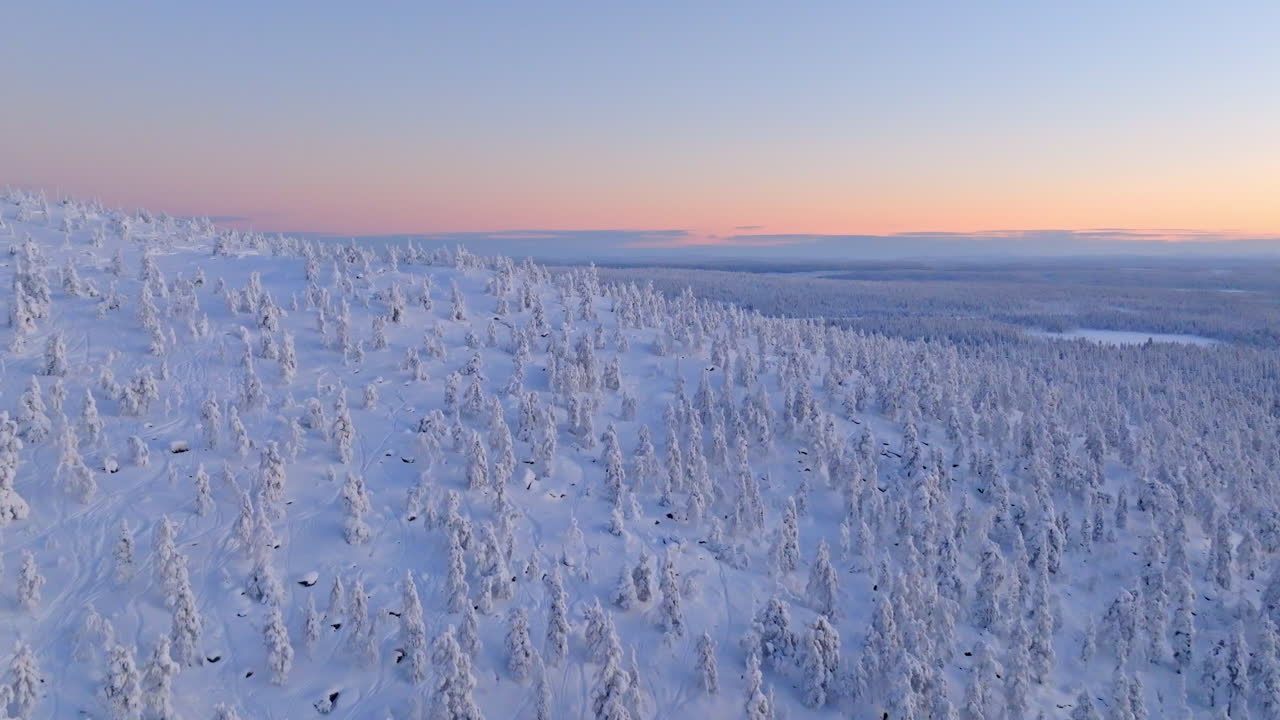 Panoramic drone shot over snowy mountain forest, polar night season in Lapland