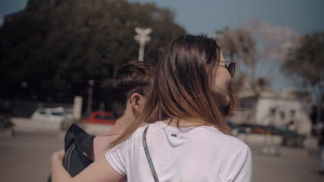 a back view of a couple walking on a sunny day