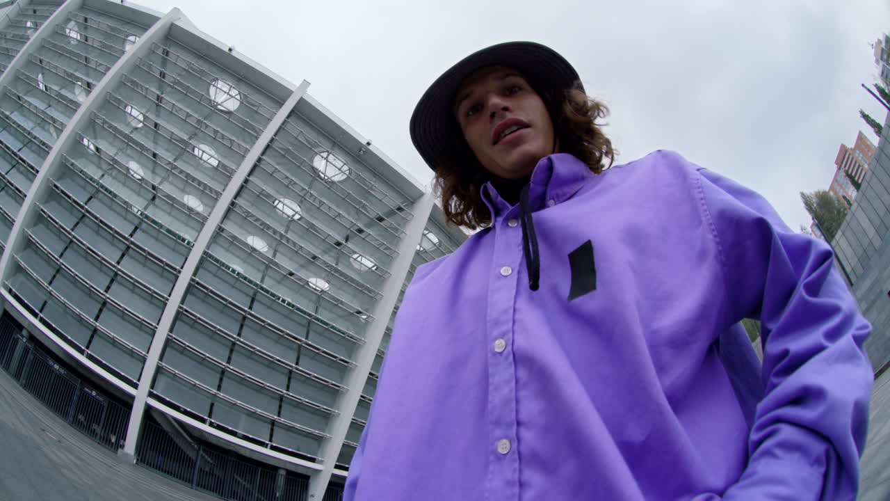 스포츠 남자의 물고기 눈 렌즈를 통해 시내 거리에서 카메라에 주먹을 보여줍니다.