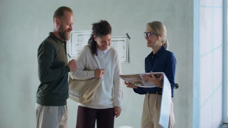 ein glückliches paar besucht ein neues haus mit einem immobilienmakler