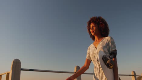 woman walking and holding a skateboard on hand