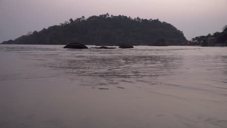 Goa,-India,-Palolem-beach-view-across-the-sea-at-sunset-with-pink-waves-calmly-moving-in-ocean-waters