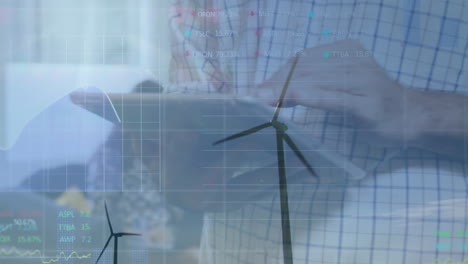 animation of financial data processing over wind turbines man with tablet