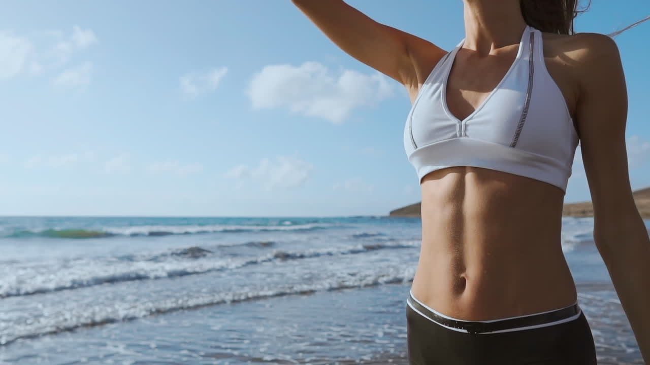 Una mujer joven caminando por la playa.