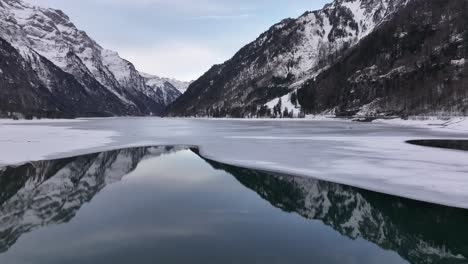 aerial frozen klöntalersee lake with swiss alps reflection in klöntal, glarus, switzerland