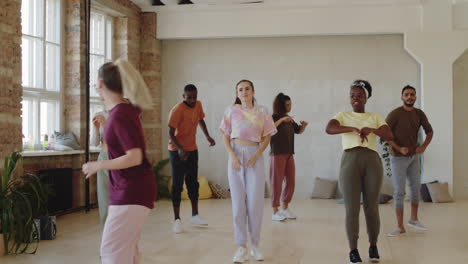 happy diverse people dancing with female coach and applauding