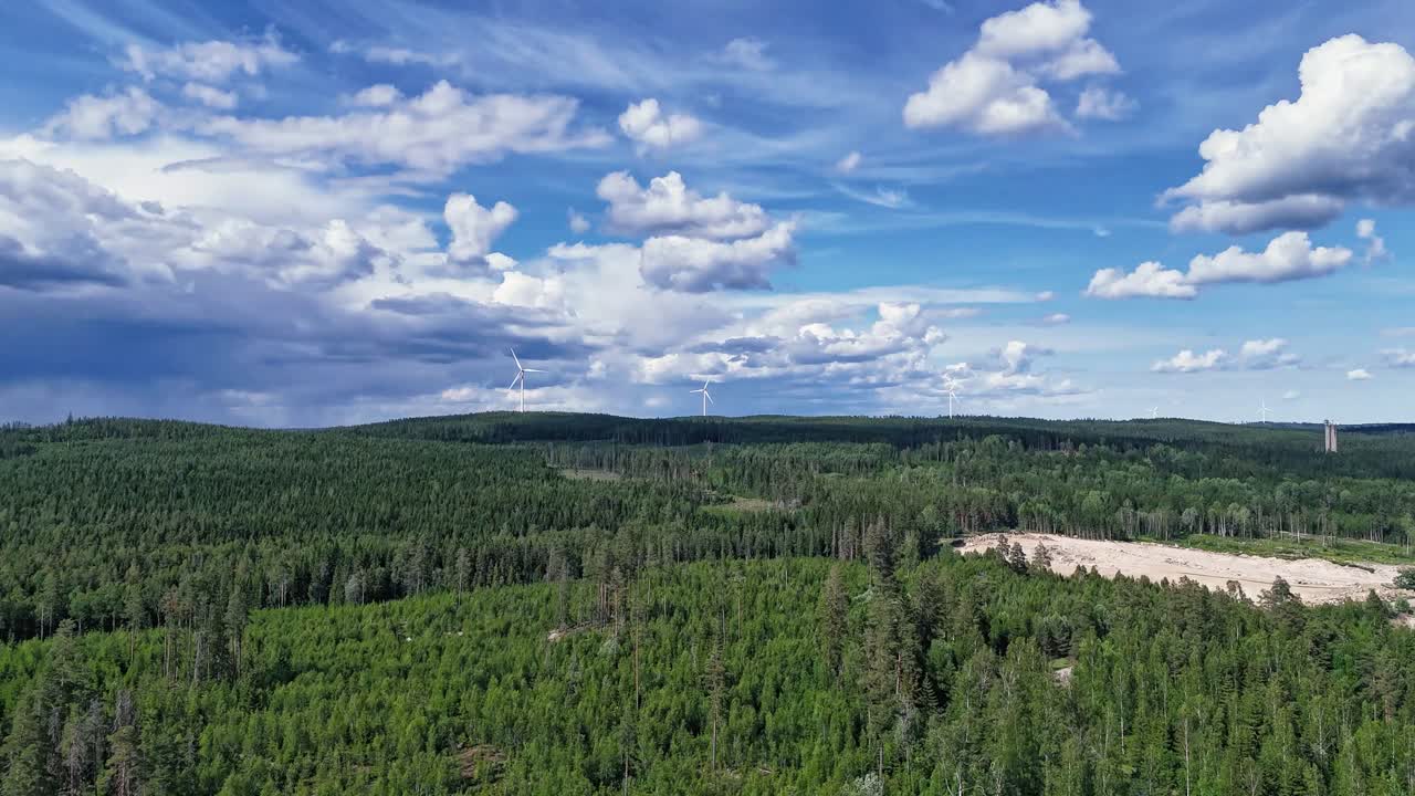Frodig skov med vindmøller i det fjerne under en levende blå himmel, hyperlapse