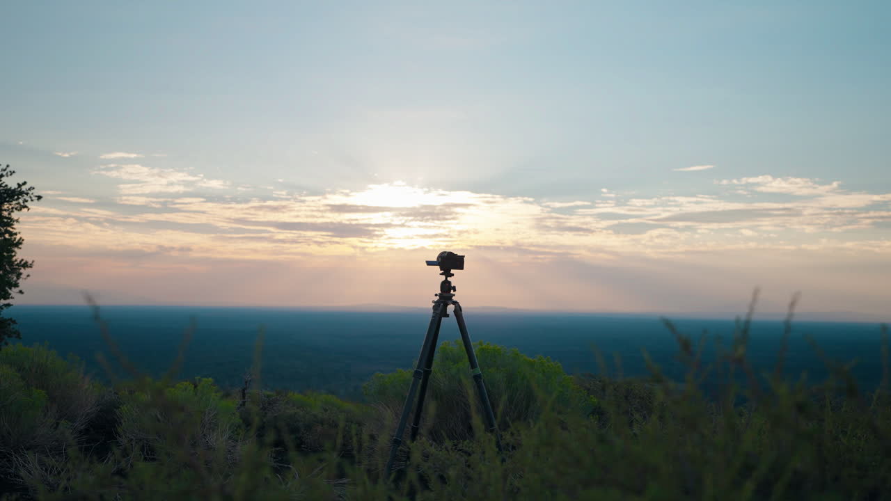 Camera on Tripod Capturing Sunset Landscape