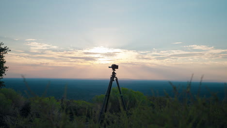 camera on tripod capturing sunset landscape