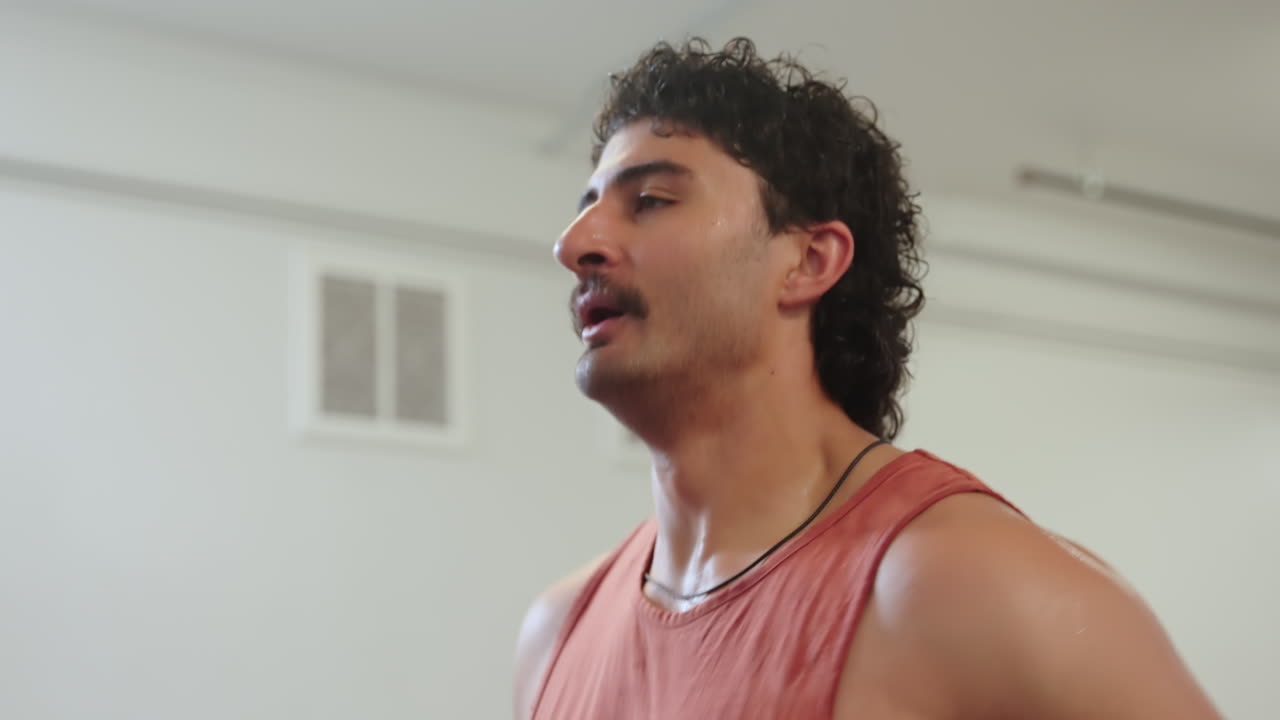 Athletic strong man running on a treadmill, close up