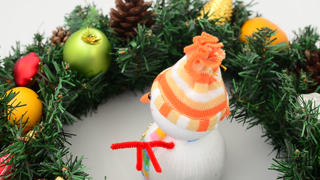 Natureza morta com pinheiro e boneco de neve. Tomada em plataforma giratória. Filmagem em movimento