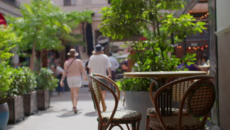 couple walking past outdoor cafe in city