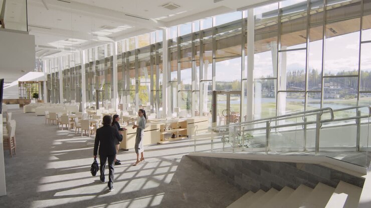 Professionisti aziendali nella hall di un moderno edificio aziendale con vista lago