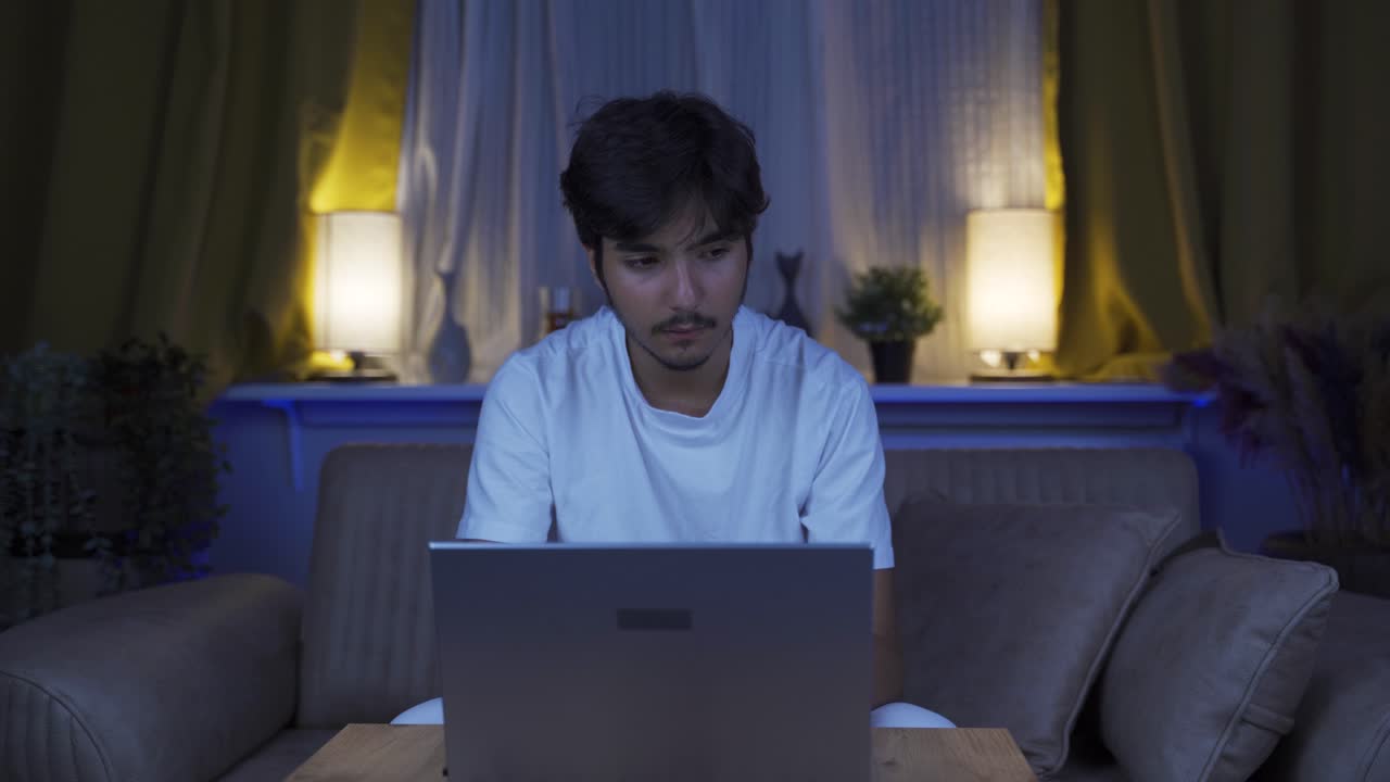 el hombre se cansa mientras usa la computadora por la noche.
