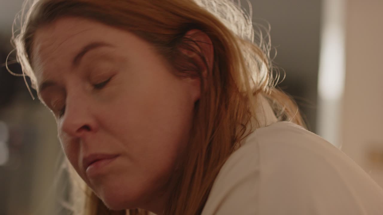 mujer en la sala de estar de repente mirando hacia arriba a un sonido