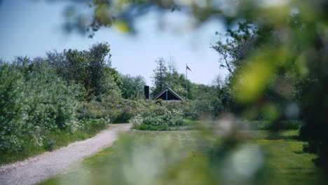 serene spring path leading to secluded wood cabin with a flag
