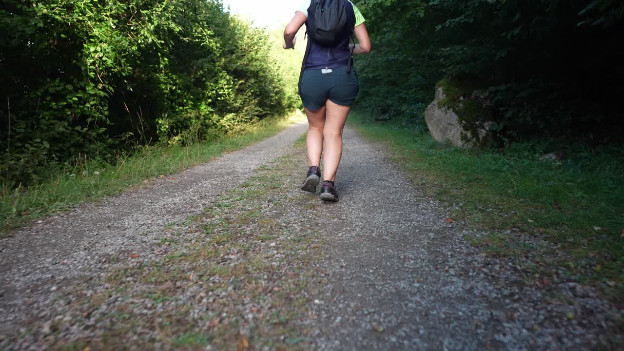 Kvinna som trailspringer i skogen