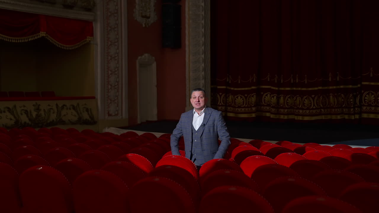 Empty theater because of pandemic. Beautiful interior of big concert hall with one man in the middle. Lockdown time.