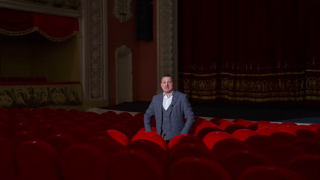 empty theater because of pandemic. beautiful interior of big concert hall with one man in the middle. lockdown time.