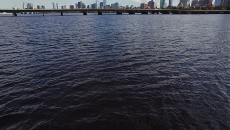 Drone-Flying-Low-Over-Water-of-Charles-River-in-Boston,-Massachusetts