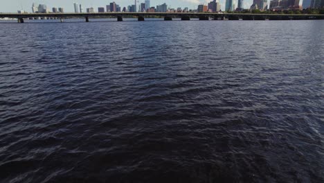 drone flying low over water of charles river in boston, massachusetts