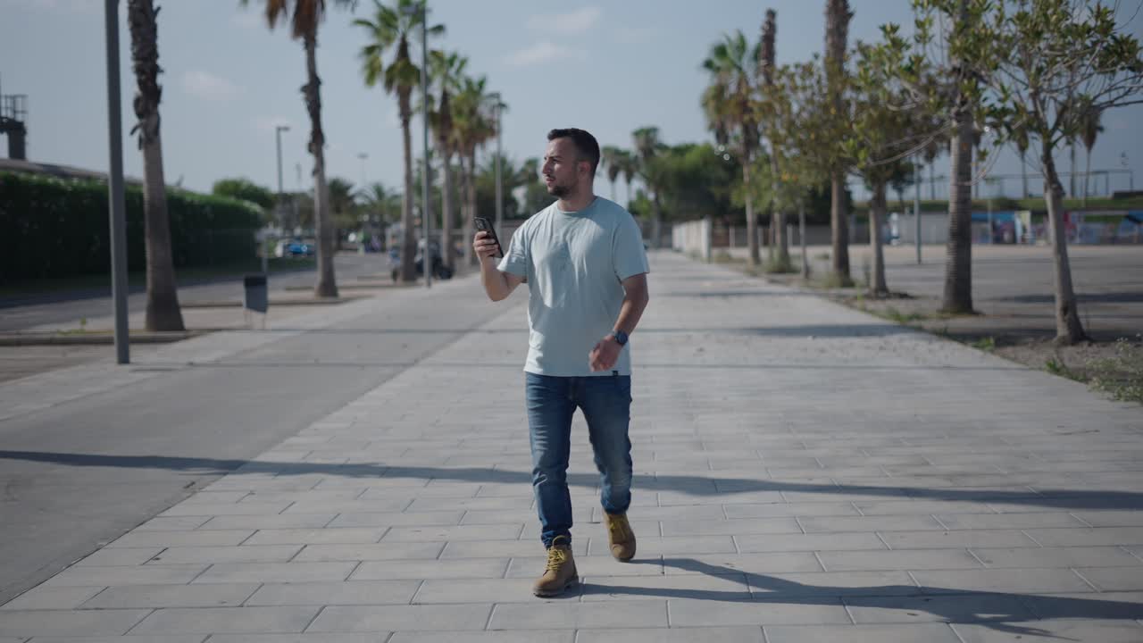 Man Walking on Sidewalk with Smartphone