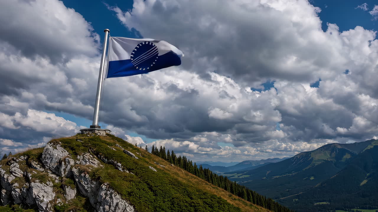 Flag on a Mountain Summit under a Cloudy Sky