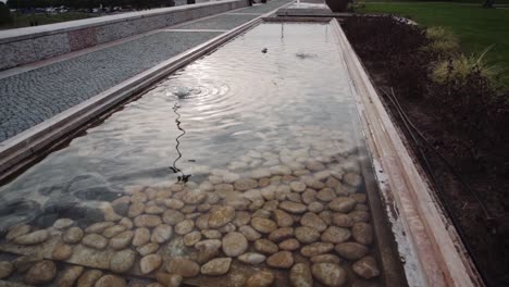 slow motion: small lake with ripples in the water and stones inside