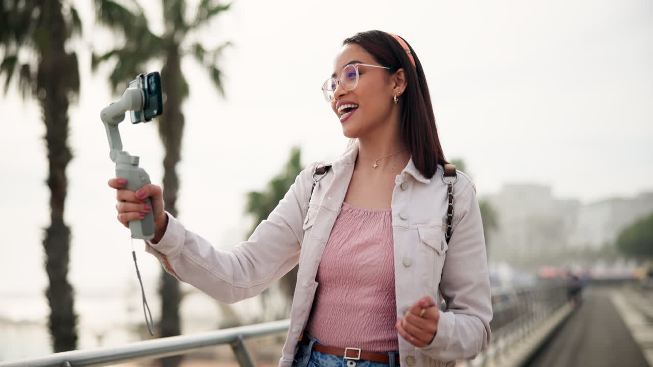 Woman vlogging outdoors with smartphone and selfie stick