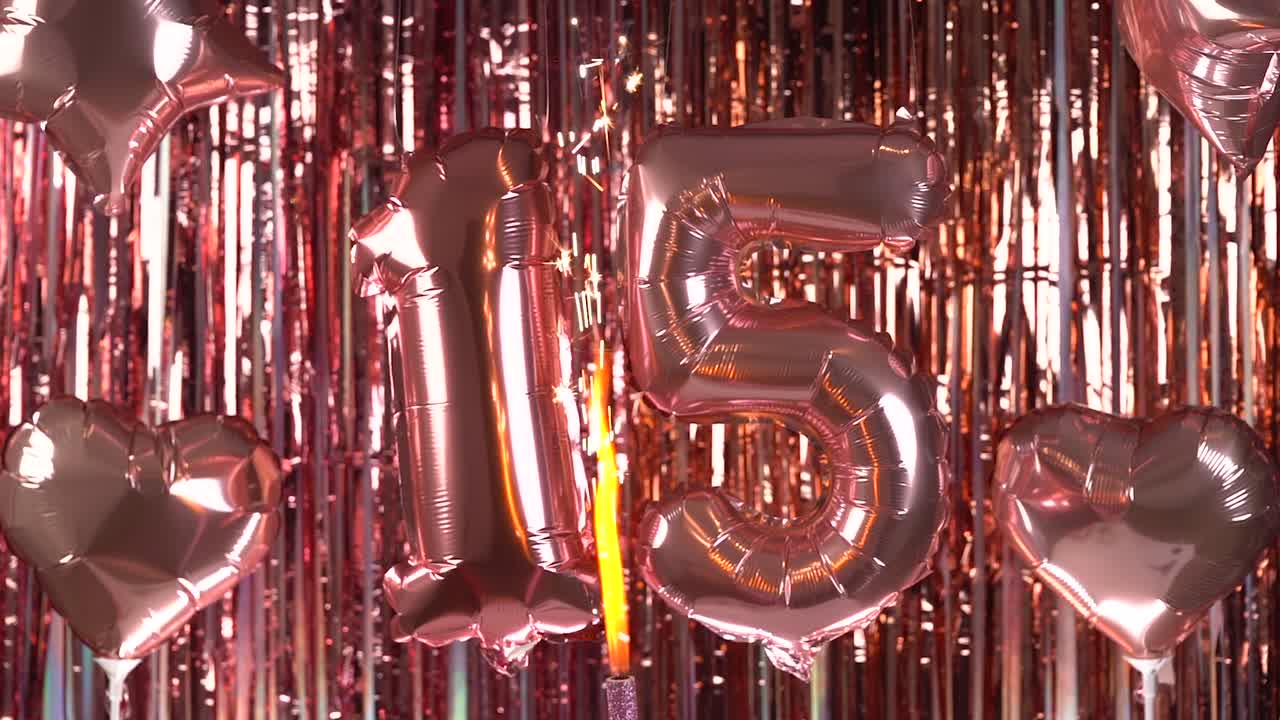 Palloncini color oro rosa numero 15 con candelina su sfondo festivo
