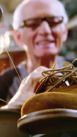 shoemaker examining a shoe